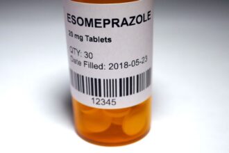 Esomeprazol tabletták egy narancssárga gyógyszeres üvegben, címkével ellátva.