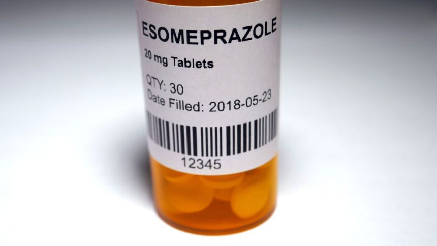 Esomeprazol tabletták egy narancssárga gyógyszeres üvegben, címkével ellátva.