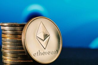 Egy Ethereum érme közelről, háttérben kék színű elmosódott mintázattal.