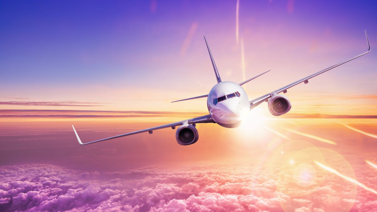 Egy repülőgép a felhők felett, naplementében, aerodinamikus formával.