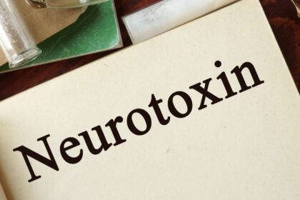 A könyv lapján a 'Neurotoxin' felirat olvasható, körülötte üvegcsék és papírok találhatók.
