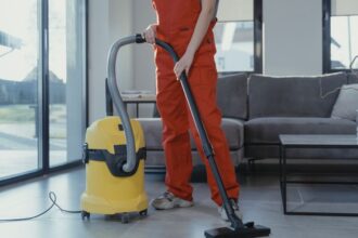 Egy személy a Kärcher WD 3 porszívóval takarít a nappaliban, modern környezetben.
