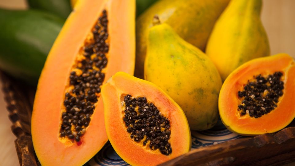 Friss papaya gyümölcsök, félbevágva, látható fekete magokkal és élénk színű hússal.