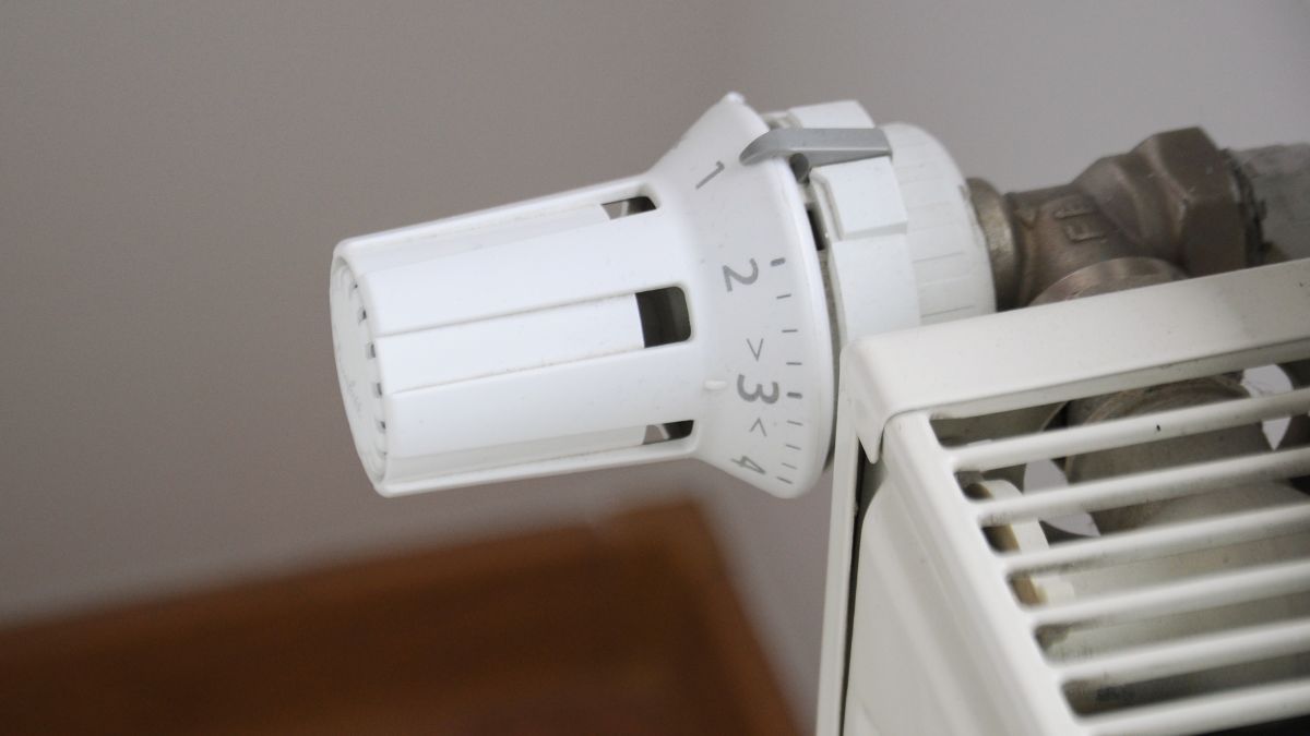 Egy radiátor termosztátfej, amely a fűtés szabályozására szolgál, a radiátor mellett.