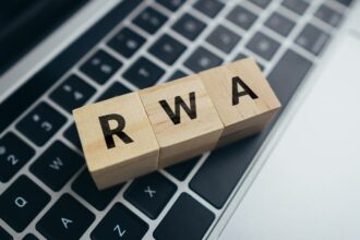 Fából készült RWA betűk egy laptop billentyűzetén, a pénzügyi kockázatok kezelésére utalva.