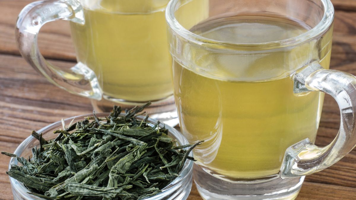 Friss Sencha zöld tea és szárított tea levelek egy tálban, természetes környezetben.