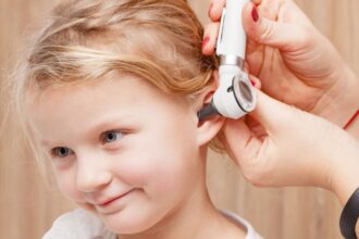 Egy gyermek fülvizsgálata, ahol egy orvos otoszkópot használ a dobhártya ellenőrzésére.