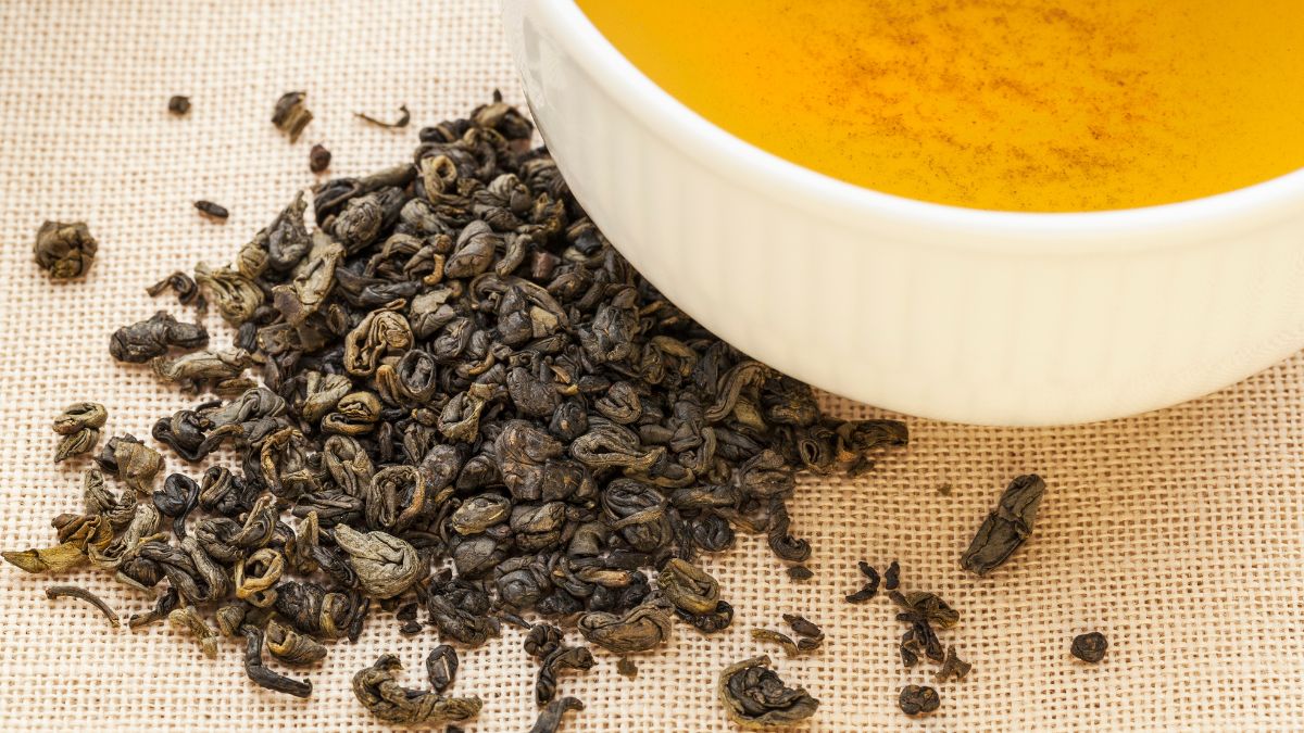 Golyós szálas tea levelek és egy csésze tea, amely gazdag ízélményt nyújt.