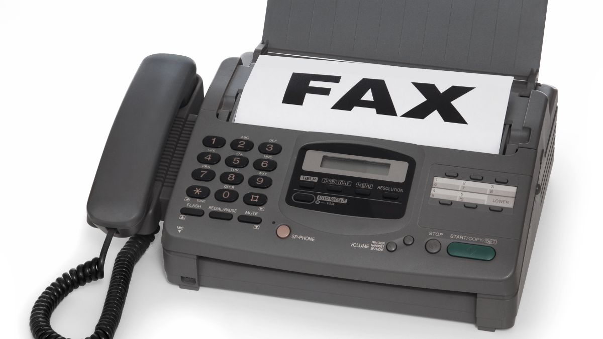 Egy faxgép, amely papíron a 'FAX' feliratot mutat, telefonkészülékkel.