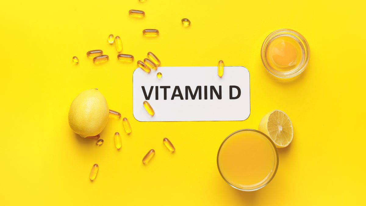 D-vitamin kapszulák, citrom és ital egy sárga háttéren, az egészséges életmód szimbólumai.