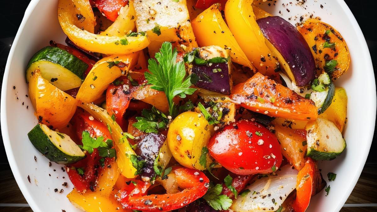 Színes zöldségek, köztük sárga, piros és zöld paprika, cukkini és petrezselyem egy tálban.