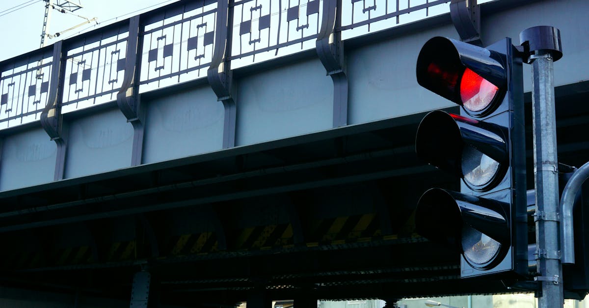 City intersection with a bridge and traffic light in focus, highlighting urban infrastructure.