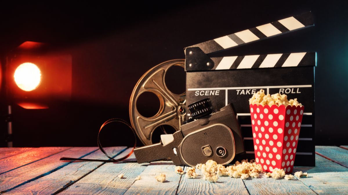 Egy filmes kellékekből álló kompozíció, klapka, filmes szalag és popcorn látható.