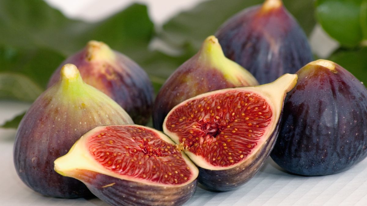Friss fügék, köztük egy félbevágott füge, amely bemutatja édes, piros belsejét.