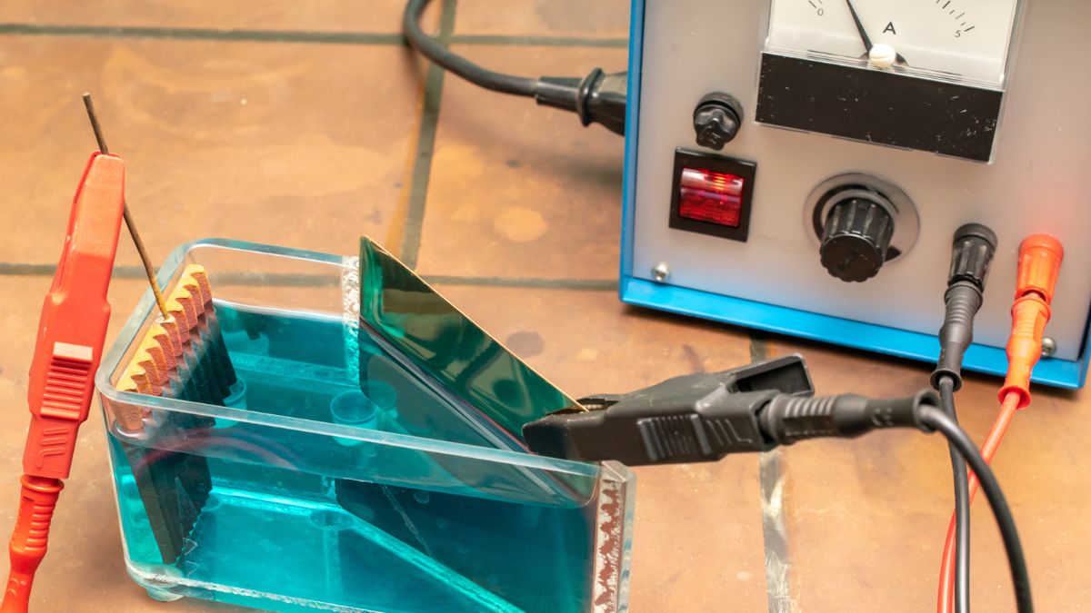 Egy galvánelem kísérlet, ahol elektrolit oldatban fémelemek vannak, mérőműszerrel.