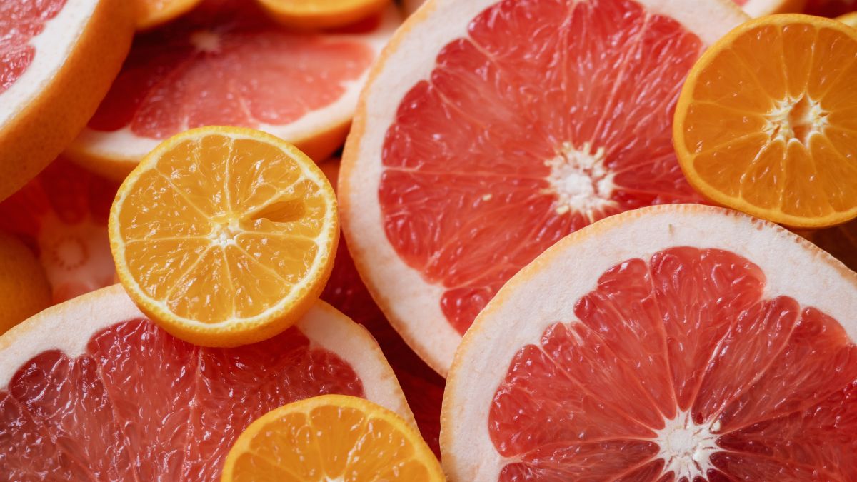 Friss grapefruit és narancs szeletek, élénk színekben, egészséges táplálkozás szimbóluma.