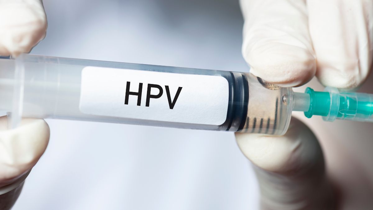 Egy kéz HPV felirattal ellátott injekciós tűt tart, ami a megelőzés fontosságát hangsúlyozza.