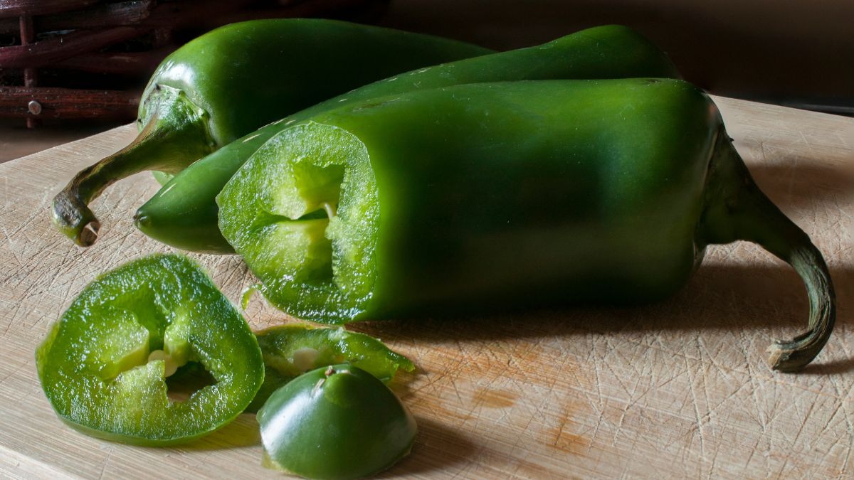 Friss jalapeño paprika, félbevágva és szeletelve, egy vágódeszkán.