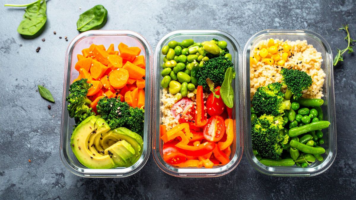 Három üvegben tálalt színes zöldségek és quinoa, egészséges vegetáriánus étkezéshez.