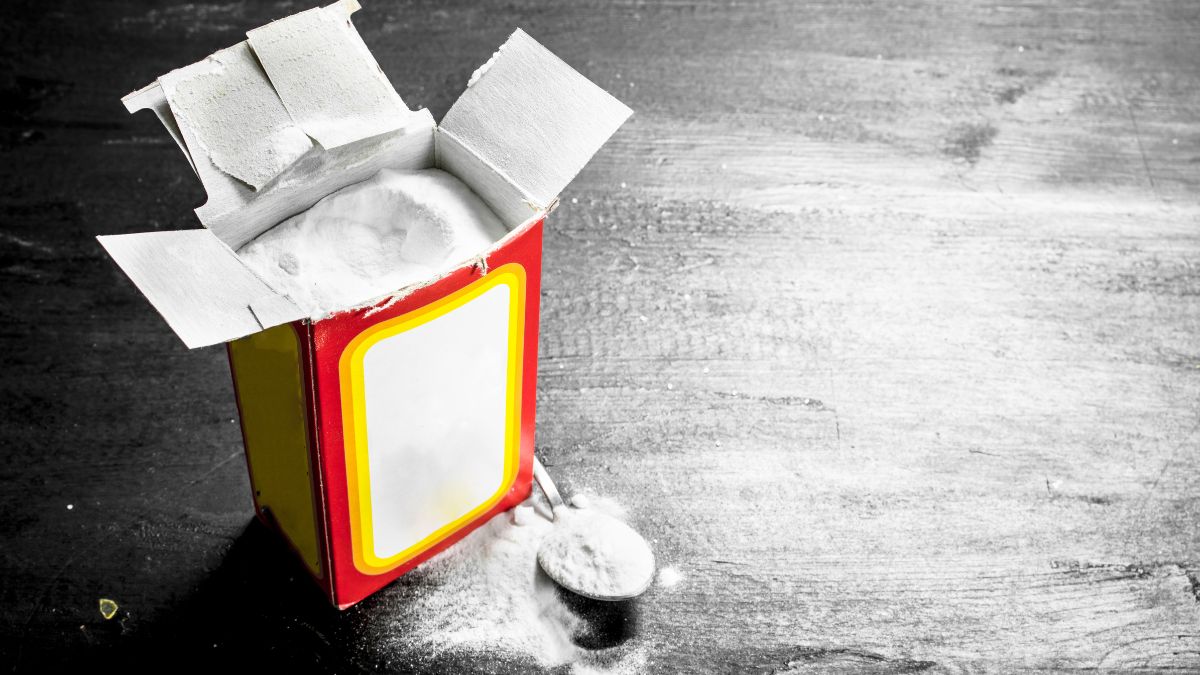 Egy nyitott szódabikarbóna doboz, amelyből por szóródik ki.