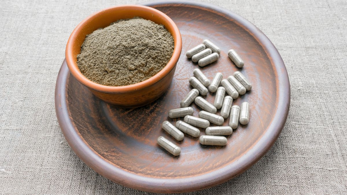 Egy tálban triphala por és mellette kapszulák, természetes egészségmegőrzéshez.