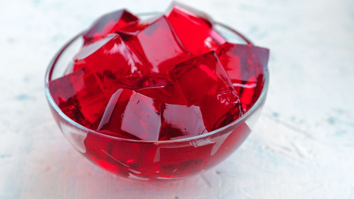 Egy tálban piros zselé kockák láthatók, friss és ízletes megjelenéssel.