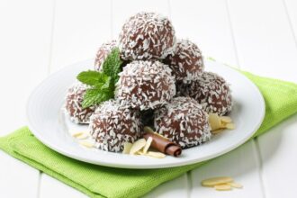 Kókuszgolyó tálalva friss kókuszreszelékkel és mandulával