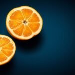 Két fél sharon gyümölcs, háttérben sötét kék színnel