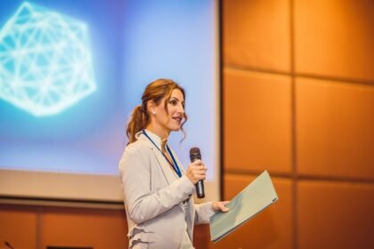 Egy nő egy konferencián elegáns mappával a kezében