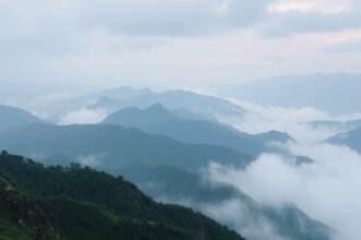 Kék hegyek és köd a horizonton, a felfedezők kalandjára utalva.