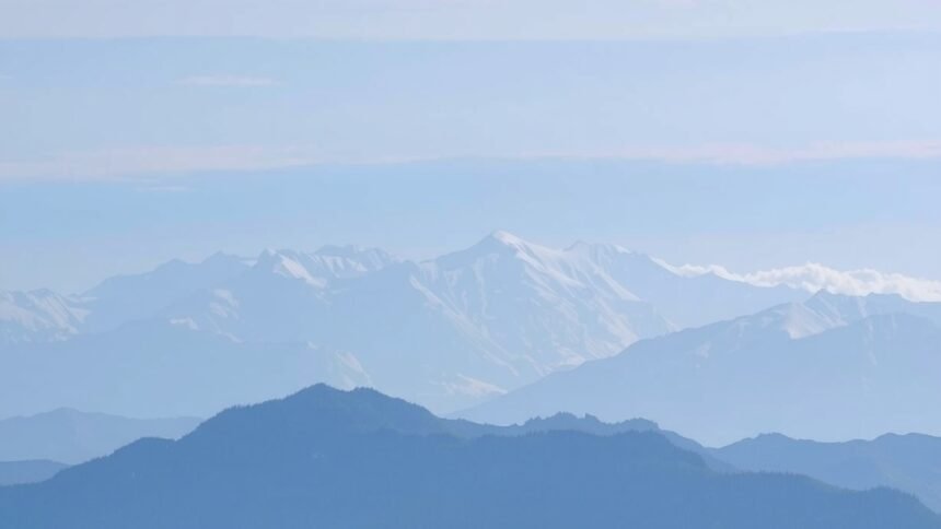 Havas hegyek és völgyek tája kék ég alatt.