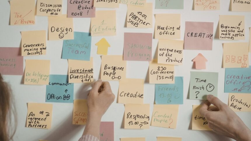 Színes Post-it cetlik irodai környezetben különböző témákkal és feladatokkal.