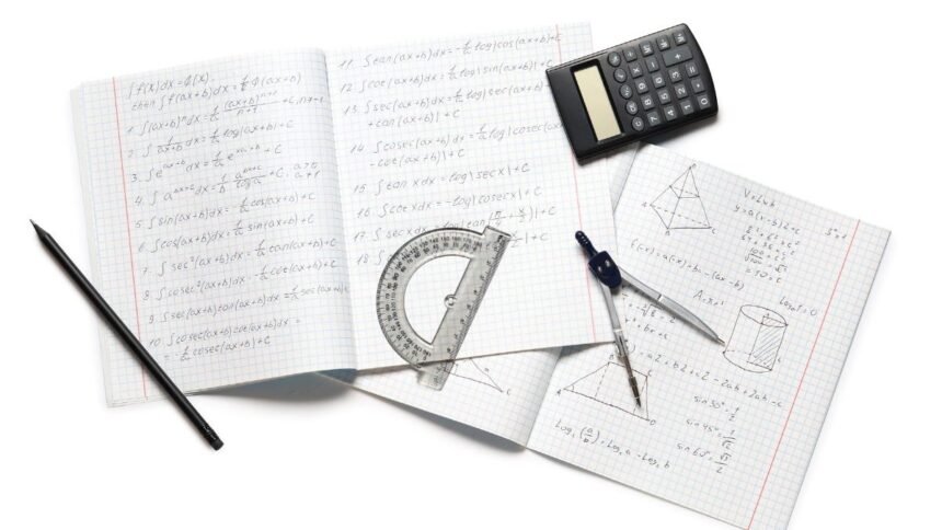 Matek eszközök: számológép, vonalzó és körzőkészlet könyvek mellett.