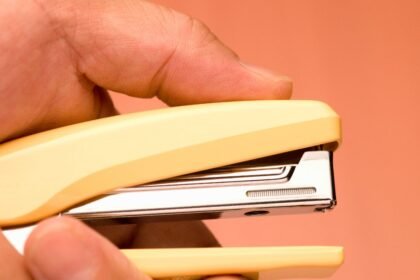 Sárga irodai tűzőgép kézben, tavaszi munkahelyi frissítéshez.