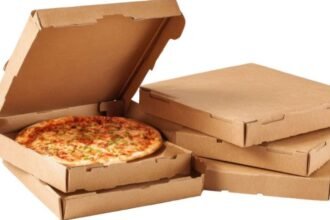 Friss pizza klasszikus pizzadobozban, háttérben üres dobozok.
