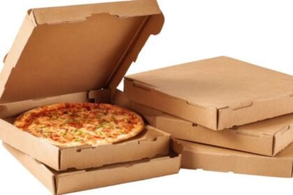 Friss pizza klasszikus pizzadobozban, háttérben üres dobozok.